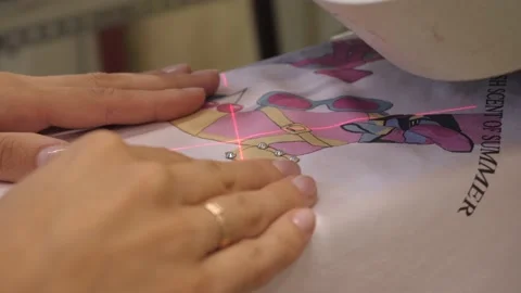 The process of applying rhinestones to clothes using an industrial machine. 動画素材 165813926