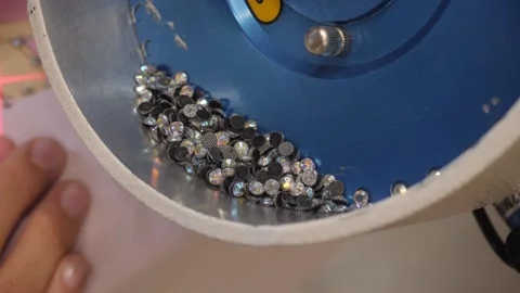The process of applying rhinestones to clothes using an industrial machine. Video stock 165815787