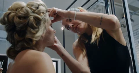 The process of applying stylish makeup unfolds within a contemporary studio Stock Footage 318218938