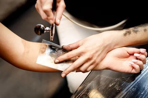 The process of applying a temporary tattoo. Stock Photos