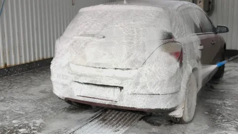 Process of applying thick white active foam on red car at self service station. Stock Footage 338251396