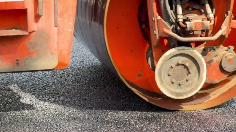 Process of asphalting, asphalt orange roller machine during construction and Stock Footage 275611765