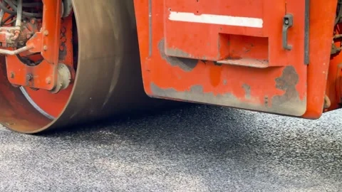 Process of asphalting, asphalt orange roller machine during construction and Stock Footage 275612358