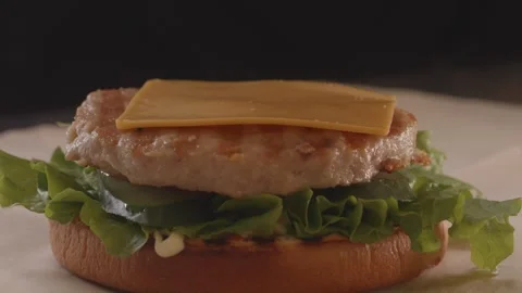 Process of assembling burger on restaurant kitchen. Stock Footage 313432387