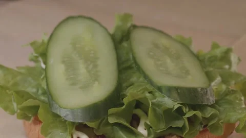 Process of assembling burger on restaurant kitchen. Stock Footage 313432430