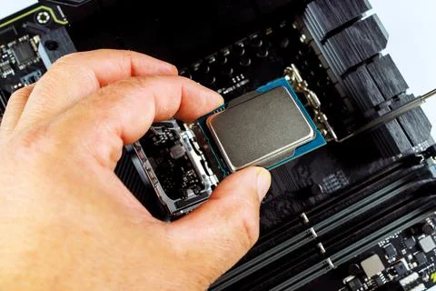 In process of assembling a desktop computer, technician is plugging CPU into 스톡 사진