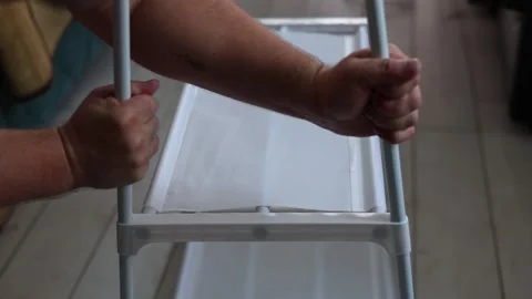 Process of assembling inexpensive new cheap rack with fabric shelf Stock Footage 319407893