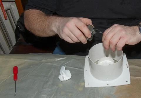 The process of assembling the kitchen exhaust fan after cleaning the wash. A  Stock Photos