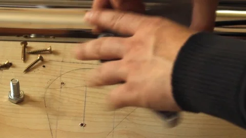 The Process of assembling the table. A young man fixes the table supports. Stock Footage 79899504