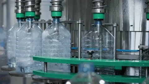Process of automatic filling of water into a plastic bottle on the filling unit Stock Footage 156073013