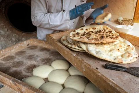 Process of baking bread in a traditional Georgian stove - tone, tandoor. A male Stock Photos