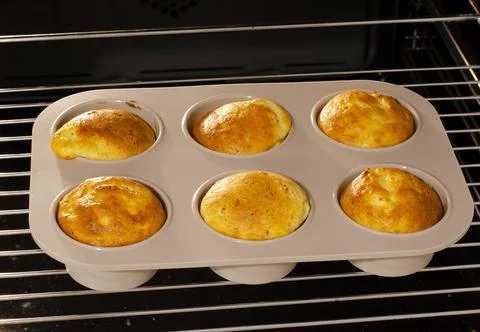 The process of baking muffins at home in the oven. Six muffins on a wire rack Foto stock
