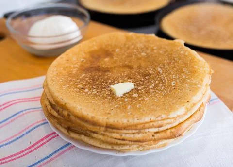Process of baking pancakes in pans on kitchen stove. stack of hot pancakes Stock Photos