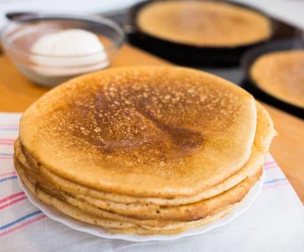 Process of baking pancakes in pans on kitchen stove. stack of hot pancakes Stock Photos