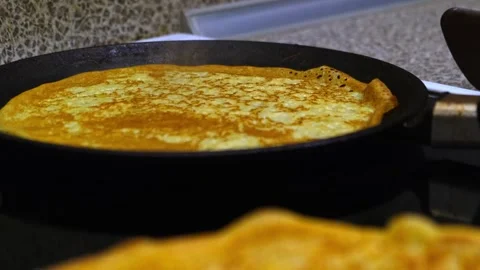 Process of baking thin pancakes on a hot frying pan. Vídeo Stock 258087476