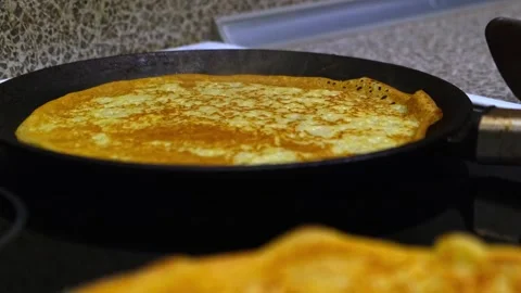 Process of baking thin pancakes on a hot frying pan. Video stock 260801778