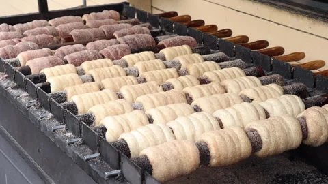 The process of baking trdelnik dough on a rotating spit	 Video stock 311927851