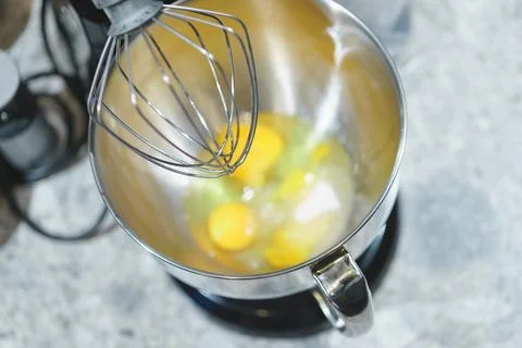 Process of beating eggs in a mixer: making homemade dough for baking. Stock Photos