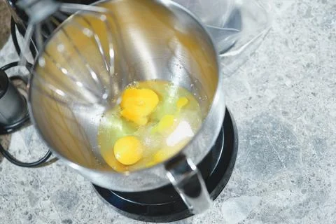 Process of beating eggs in a mixer: making homemade dough for baking. Stock Photos