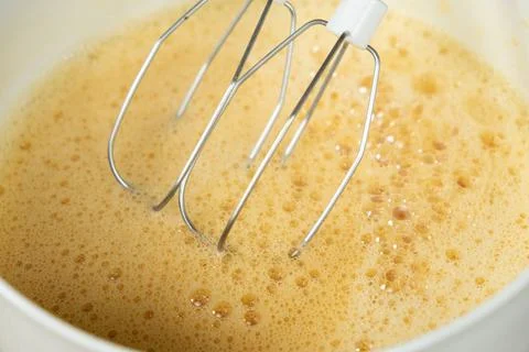 The process of beating eggs with sugar with a mixer, close-up, making the dou Stock Photos