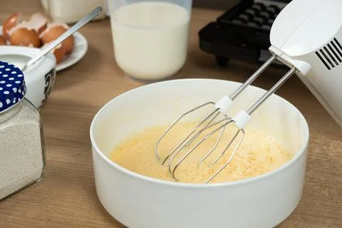 The process of beating eggs with sugar with a mixer, close-up, making the dough. Stock Photos