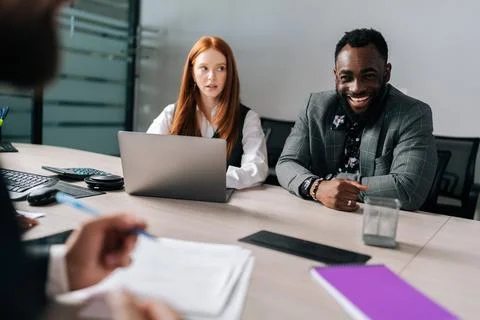 Process in boardroom between multiethnic positive business partners. Diverse Stock Photos