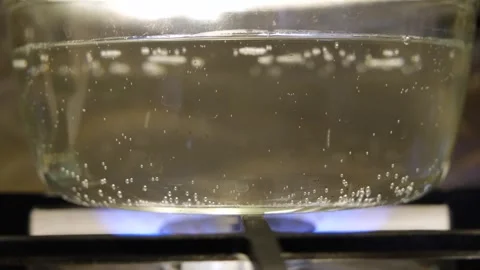 The process of boiling water slow motion. Water is boiling in a pan close-up Stock Footage 317402795