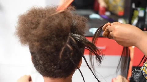 The process of braiding African braids on the mixed boy Stock Footage 140154217