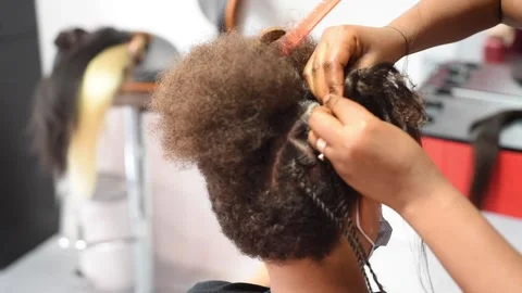 The process of braiding African braids on the mixed boy Stock Footage 140154220