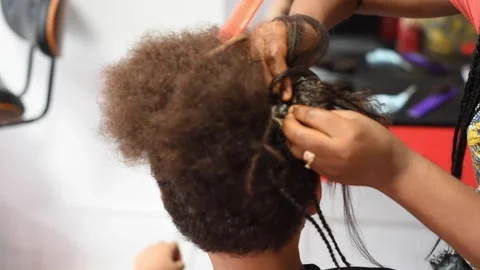 The process of braiding African braids on the mixed boy Stock Footage 140154232