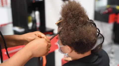 The process of braiding African braids on the mixed boy Stock Footage 140154242