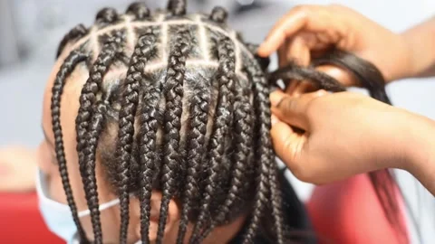 The process of braiding African braids on the mixed boy Stock Footage 140154273