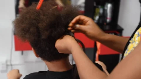 The process of braiding African braids on the mixed boy Stock Footage 140154298