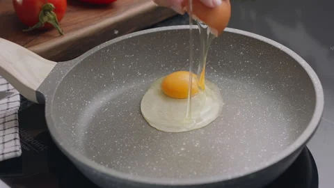 Process of breaking an egg on a frying pan. Stock Footage 311801362