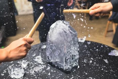 Process of breaking the ice with hammer and ice pick, group of people smashin Stock Photos