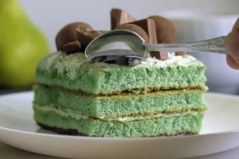 Process of breaking off a piece of a green  cake Stock Photos
