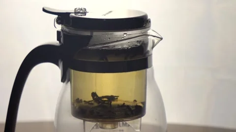 Process of Brewing black tea in transparent glass kettle Stock Footage 162846870