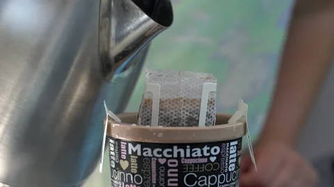 The process of brewing coffee. Water is poured into a drip coffee bag in a mug. Stock Footage 204070496