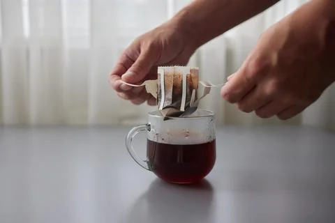 The process of brewing coffee. Water is poured into a drip coffee bag in a mug Stock Photos
