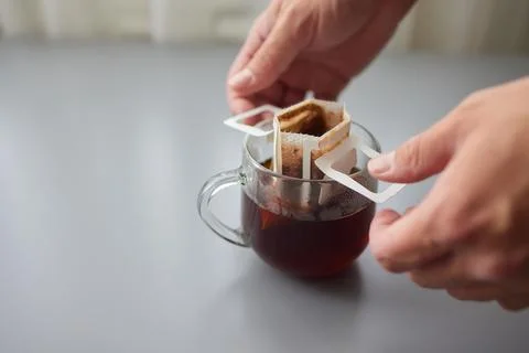The process of brewing coffee. Water is poured into a drip coffee bag in a mug Stock Photos