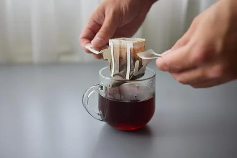 The process of brewing coffee. Water is poured into a drip coffee bag in a mug Stock Photos