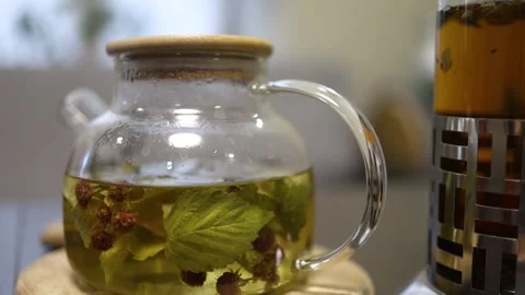 Process of Brewing green herbal tea with mint in transparent glass tea pot Stock Footage 164162529