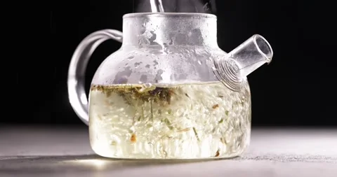 Process of brewing herbal tea in glass transparent teapot at dark background Stock-Footage 172208677