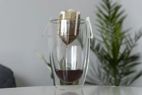 The process of brewing a morning coffee drip with a filter bag in a double Stock Photos