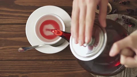 The process of brewing red tea with hibiscus. Step four. Female hands pourin Video stock 155553775