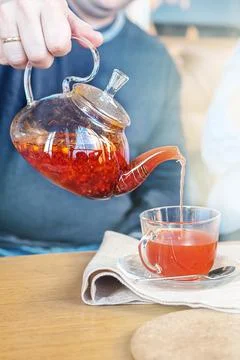 Process of brewing tea, a Cup of freshly brewed fruit tea of red fruit and ho Stock Photos