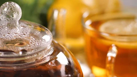 Process of brewing tea in a glass transparent teapot with drops of condensate Stock Footage 104092539