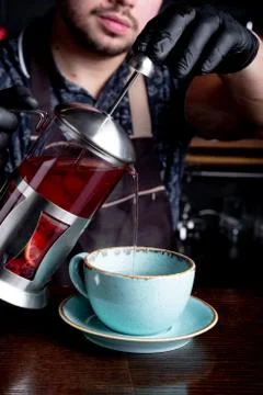 Process brewing tea,tea ceremony. Bartender pours hot fruit or berry tea into Stock Photos
