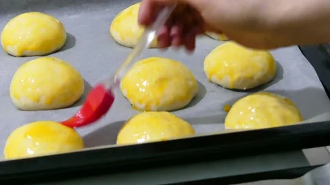 The process of brushing eggs on raw pastry dough on baking paper, Stock Footage 166705167