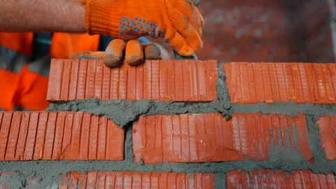 The process of building a brick wall. The builder is laying the bricks. Vidéo 167728670